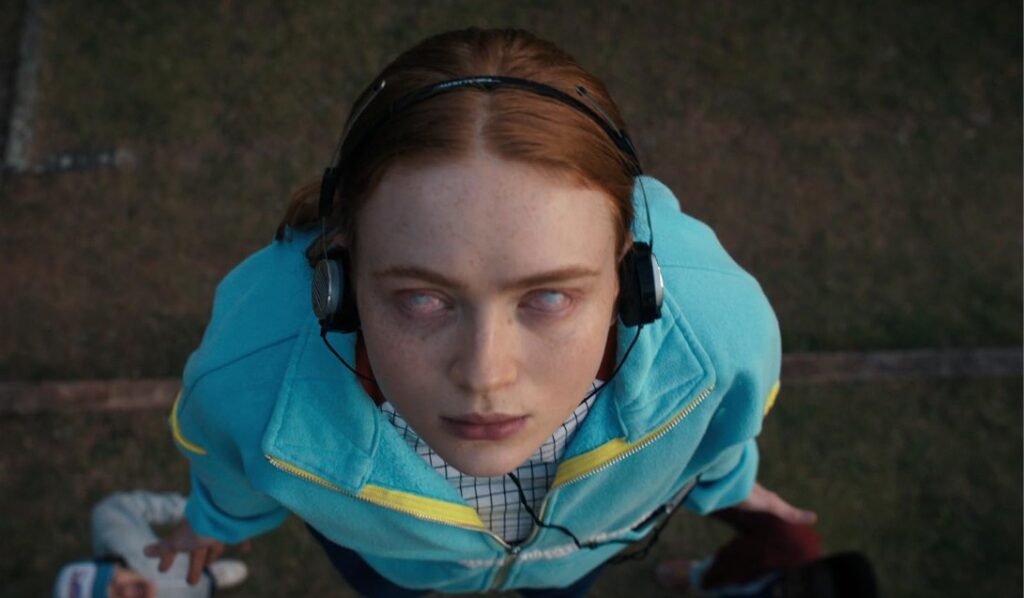 Sadie Sink as Max Mayfield in a chilling still from Stranger Things, looking possessed during a tense moment.