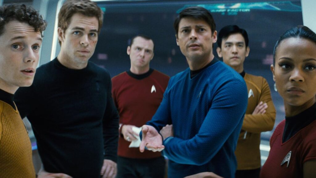 John Cho, Simon Pegg, Zoe Saldaña, Karl Urban, Anton Yelchin, and Chris Pine looking at something in Star Trek