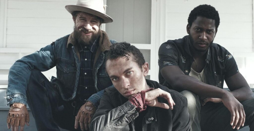 Brendan Bradley, Nican Robinson, and Jordon Bolden sitting together, striking a pose in a scene from The Devil and the Daylong Brothers.