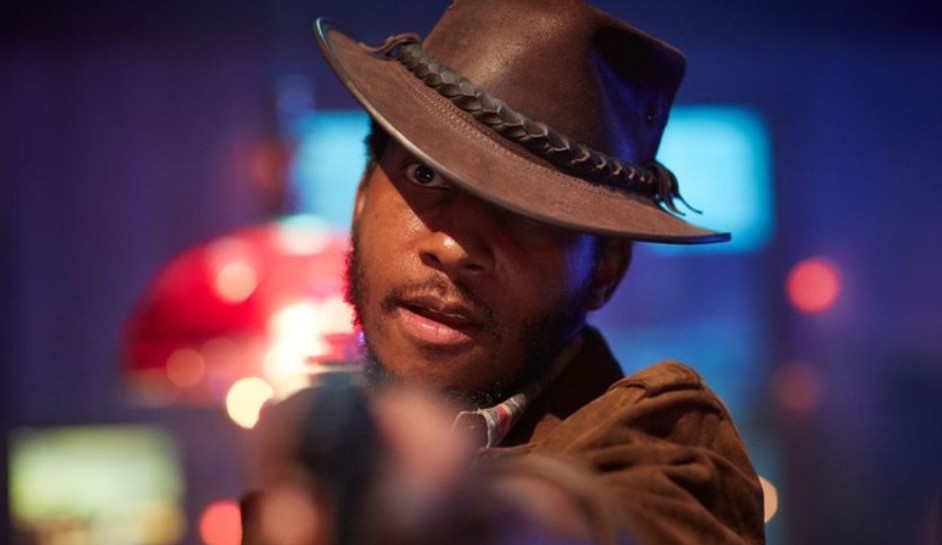 The character is pointing a gun with a steely gaze, preparing for a high-stakes confrontation.



