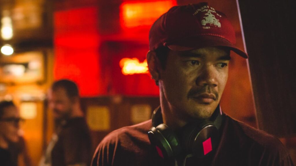 Destin Daniel Cretton on the set of The Glass Castle wearing a red shirt and a red cap.