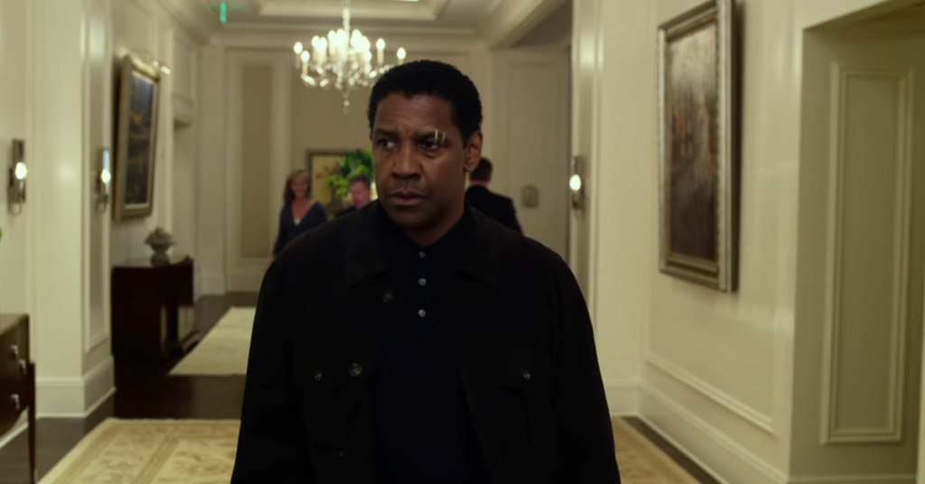 Denzel Washington as White Whitaker walking the lobby of a hotel. 