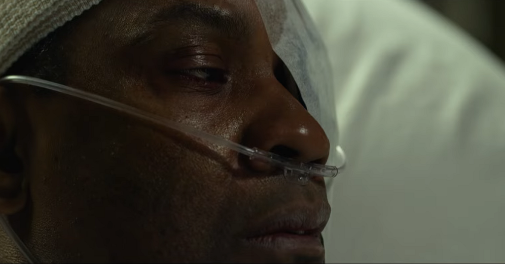 Whitaker's face covered in bandages and tubes at a hospital. 