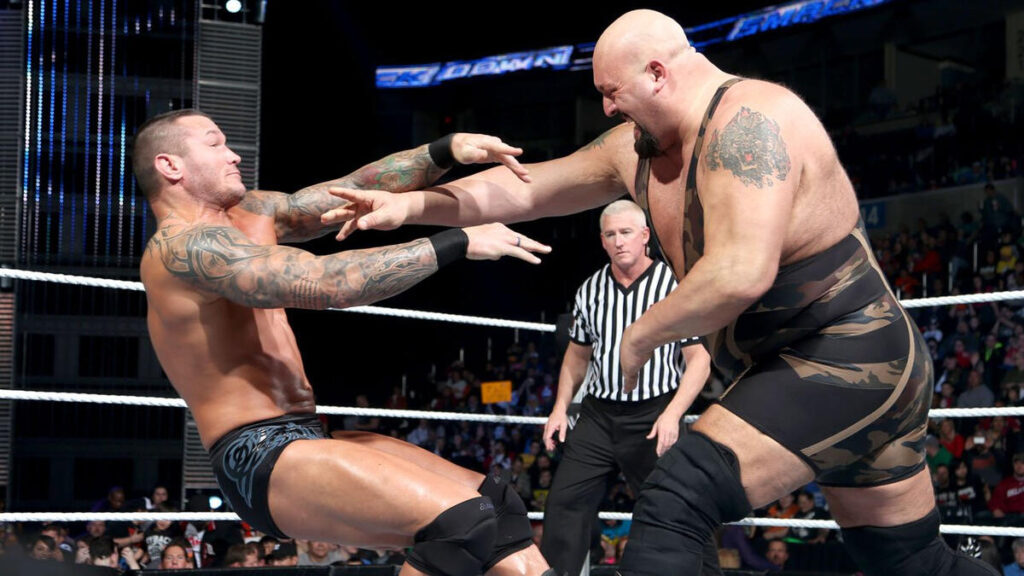 Randy Orton and Big Show fight inside the ring as the referee looks on.