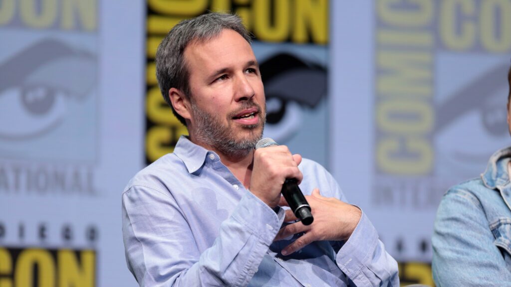 10 Most Successful Non-American Directors in Hollywood 7 Denis Villeneuve wearing a blue shirt and speaking into a microphone at 2017 San Diego Comic Con International, for "Blade Runner 2049."