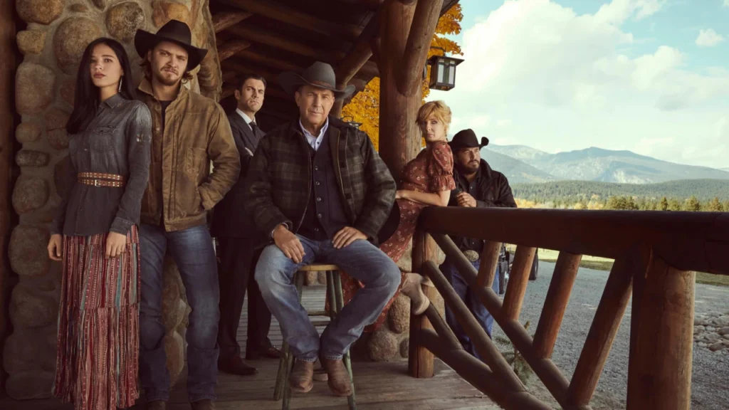 The Dutton family, sitting on their front porch on the Ranch in a still from Taylor Sheridan's Yellowstone.