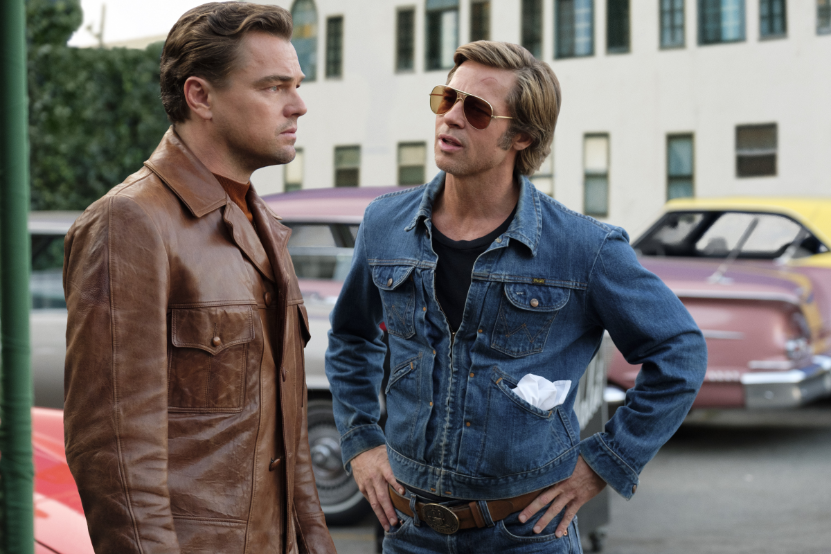 Brad Pitt as Cliff Booth looking at Leonardo DiCaprio as Rick Dalton as he’s talking, in Once Upon a Time in Hollywood.