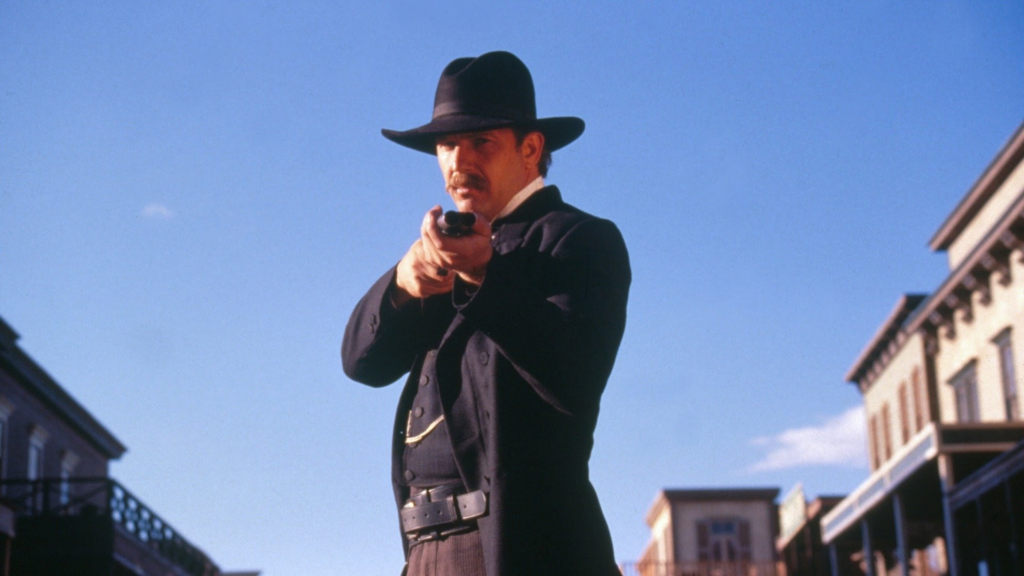 Real Reason Why Kevin Costner Lost to Val Kilmer in the ‘90s Western Race Despite Winning an Oscar 2 Kevin Costner in Wyatt Earp holding a gun.