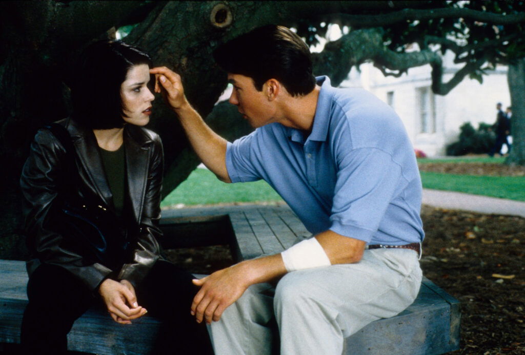 Every Actor Returning to Franchise for The Sequel 3 David Arquette tucking away a woman's hair in Scream 2.