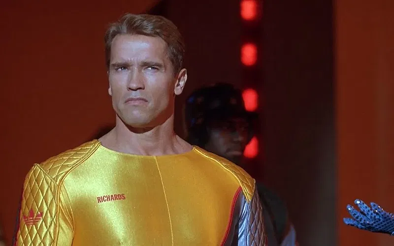 Every Stephen King Book It: Welcome to Derry Could Connect to or Plot Twist, Ranked Arnold Schwarzeneggar in a yellow leotard in The Running Man