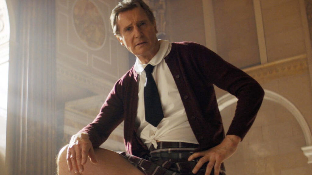 ‘The Naked Gun’ Trailer: Liam Neeson Proves David Zucker Shouldn’t Compare It To Internet’s Most Infamous Video 1 Liam Neeson, in a school uniform, standing with his right leg on a platform in a still from The Naked Gun.