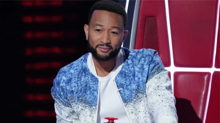 John Legend, sitting in the red judge's chair in the reality show The Voice.