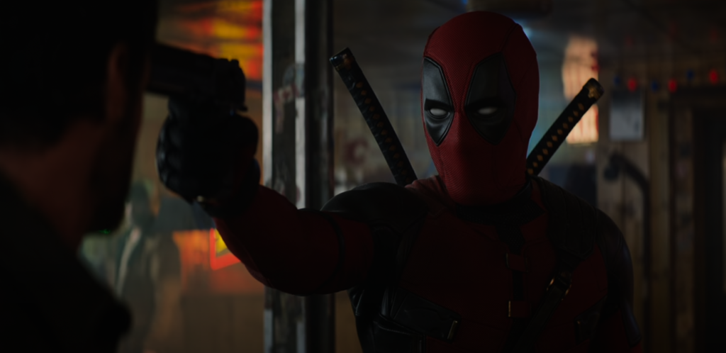 Deadpool holds Wolverine with a gun held up