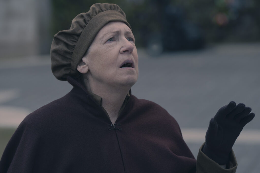 Anne Dowd in "Shattered" - The Handmaid's Tale. She looks up at something off camera.