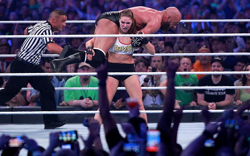Ronda Rousey carrying Triple H during a match
