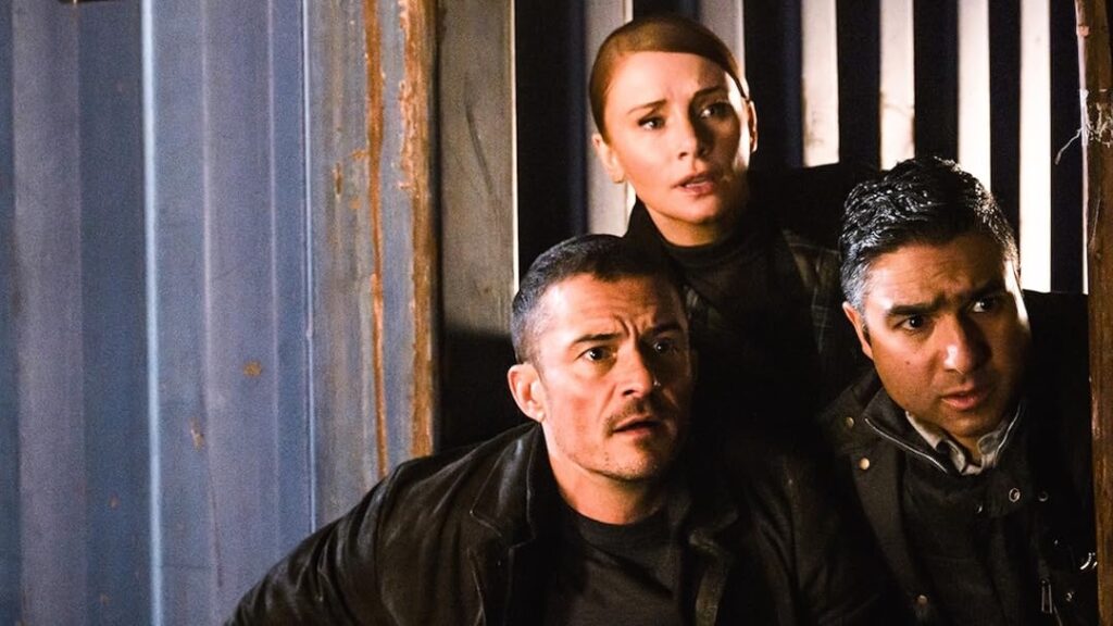 5 Movies and TV Shows Coming to Prime Video Next Month (June 2025) 1 Orlando Bloom, Bryce Dallas Howard, and Nick Mohammed cautiously peer around a corner in a tense moment from Deep Cover.
