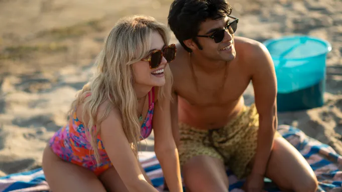 5 Movies and TV Shows Coming to Prime Video Next Month (June 2025) 4 A girl and a man sitting down on the beach with wide smiles