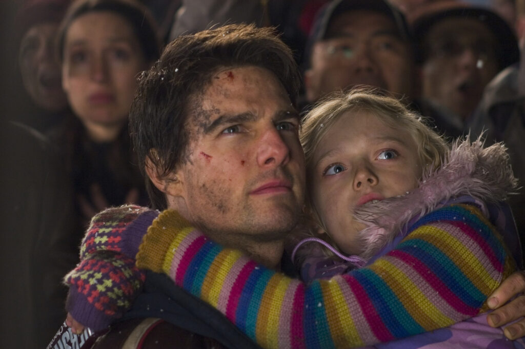 Tom Cruise holds Dakota Fanning while both look at the top