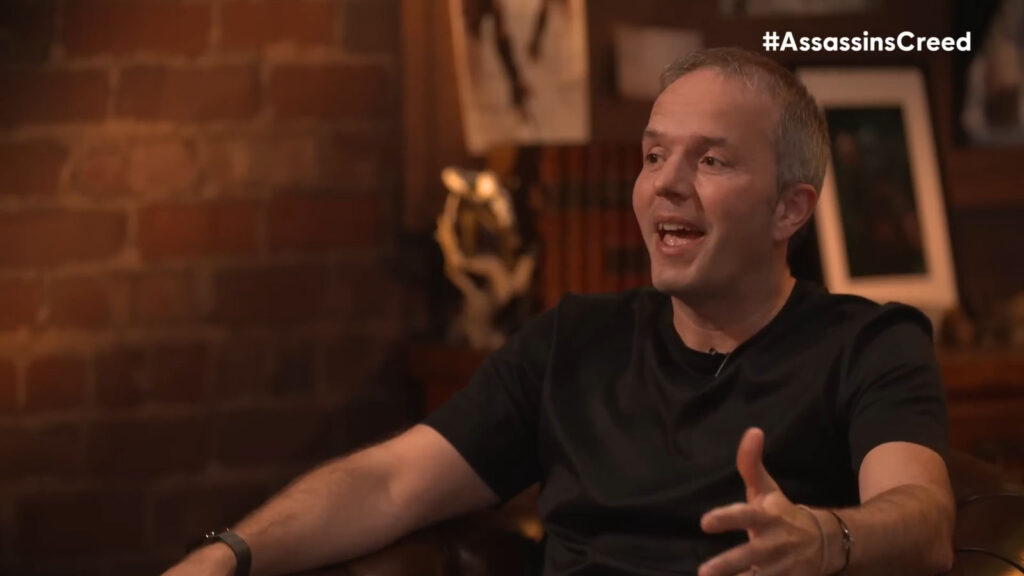 the image shows Marc-Alexis Cote explaining details about Assassin’s Creed Hexe