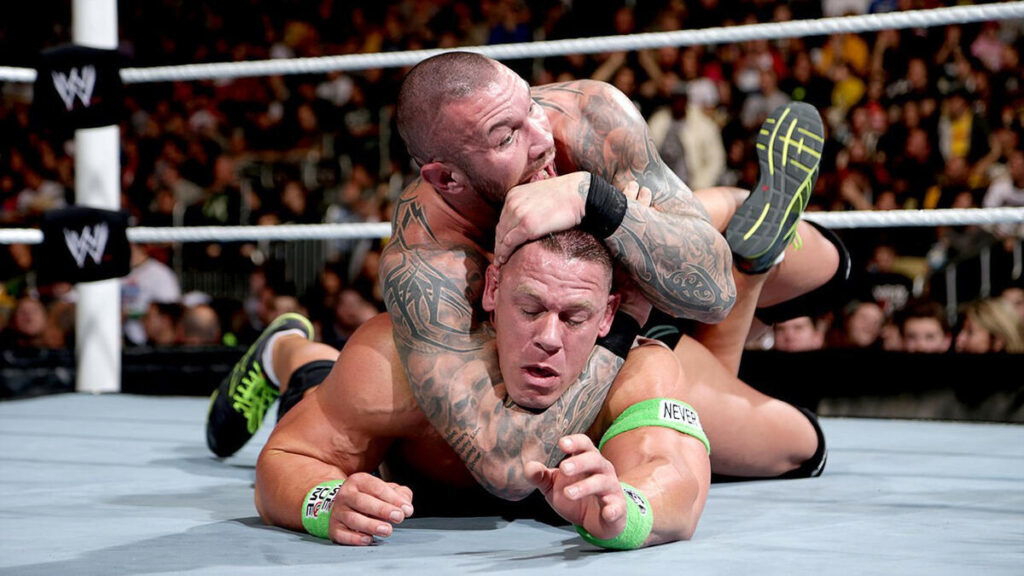 Randy Orton locking John Cena in a STF submission hold