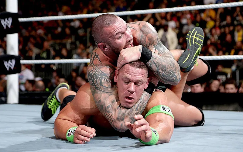 Randy Orton locking John Cena in a STF submission hold