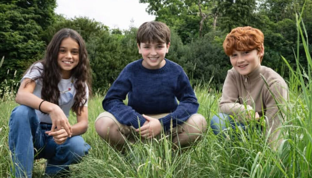 HBO's 'Harry Potter' Cast Update: 9 More Actors Confirmed, Roles Revealed 6 Arabella Stanton, Dominic McLaughlin, and Alastair Stout sitting on the grass as Hermione, Harry, and Ron