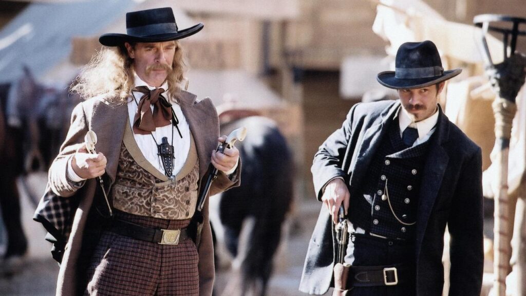 Wild Bill Hickok and Al Swearengen in a still from Deadwood walking down the market