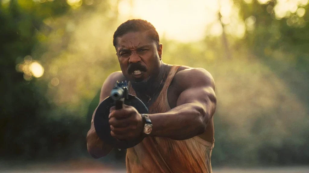 Michael B. Jordan Has His Eyes Set on a Live-Action Anime Adaptation 1 Michael B. Jordan shooting with a gun in a still from Sinners