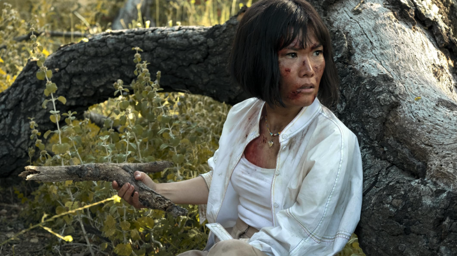 20 Absolutely Best TV Shows to Watch Right Now (June 2025) 46 Amy Lau is hiding behind a tree. She is holding a broken branch like a weapon. Her face is full of cuts here and there.