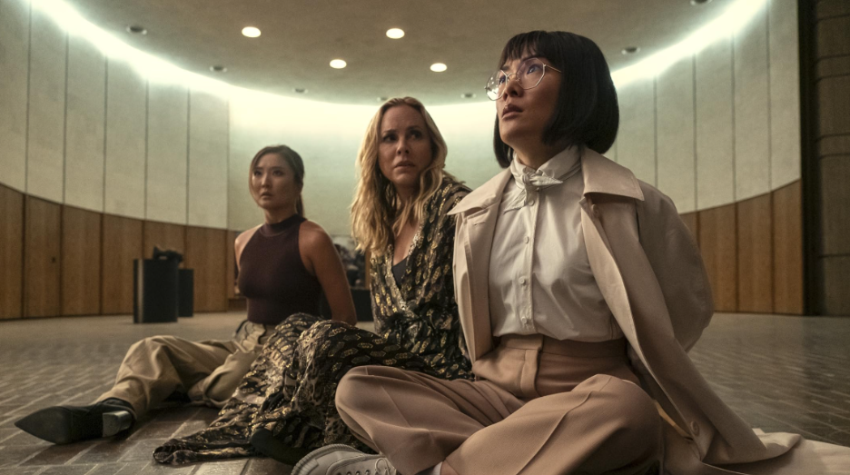 20 Absolutely Best TV Shows to Watch Right Now (June 2025) 50 Amy is sitting cross-legged on the floor along with Jordan and Naomi. It looks like all their hands are tied at the back.