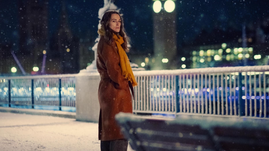 20 Absolutely Best TV Shows to Watch Right Now (June 2025) 26 Helen is looking at the empty bench. She is standing with her hands in her coat pockets.