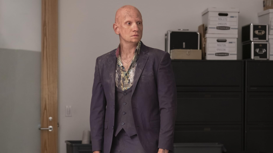 20 Absolutely Best TV Shows to Watch Right Now (June 2025) 42 NoHo is looking at someone. He is wearing a purple-ish suit.