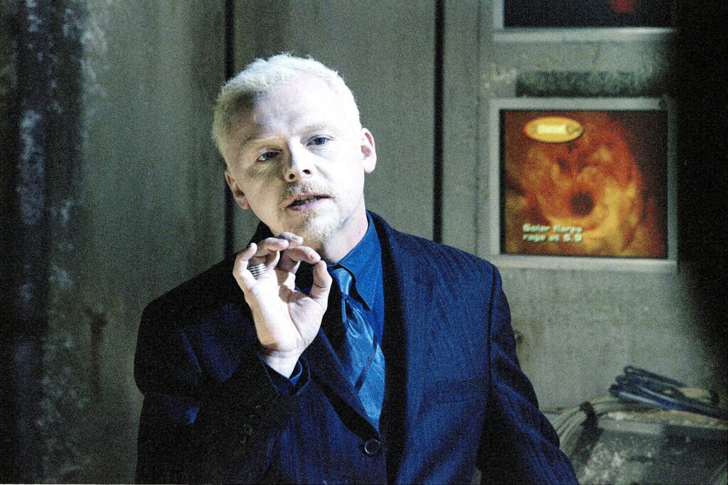 Simon Pegg Credits James Doohan’s Legacy for Completing His Nerd Hat Trick 3 Simon Pegg, in a suit with white hair, and creating a circle with his thumb and finger, in a still from Doctor Who.