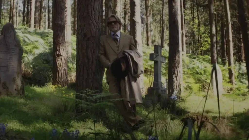 Daniel Craig in a still from Knives Out 3 leaning on a tree