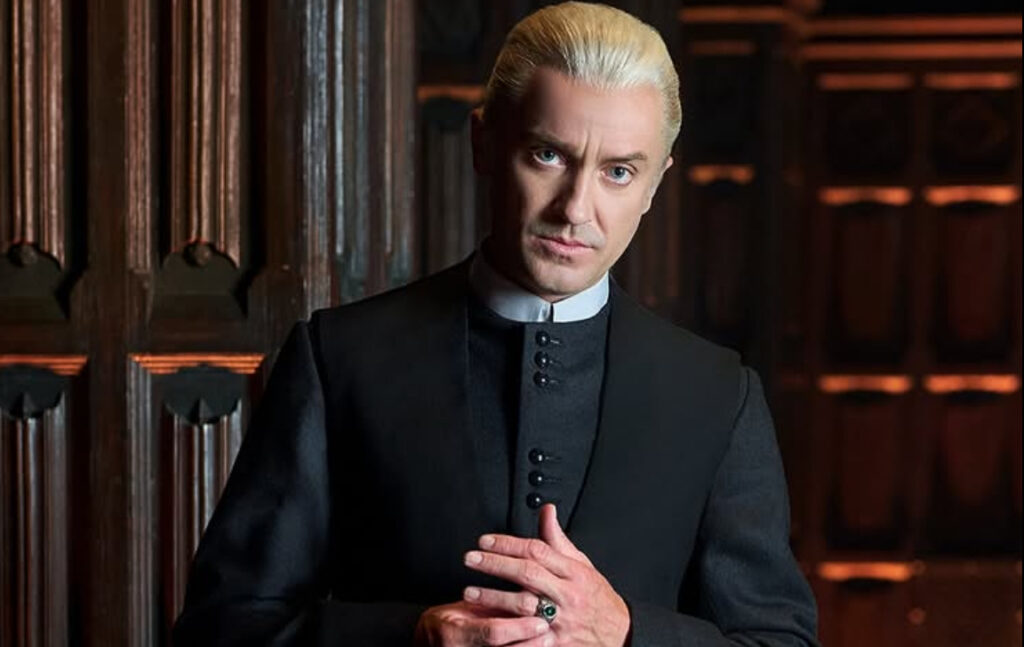 Tom Felton’s Salary for Playing Draco in ‘Harry Potter’ and How Much He Earned From All 8 Movies 3 Tom Felton with brushed-back blonde hair and his sleek black suit as an adult Draco Malfoy