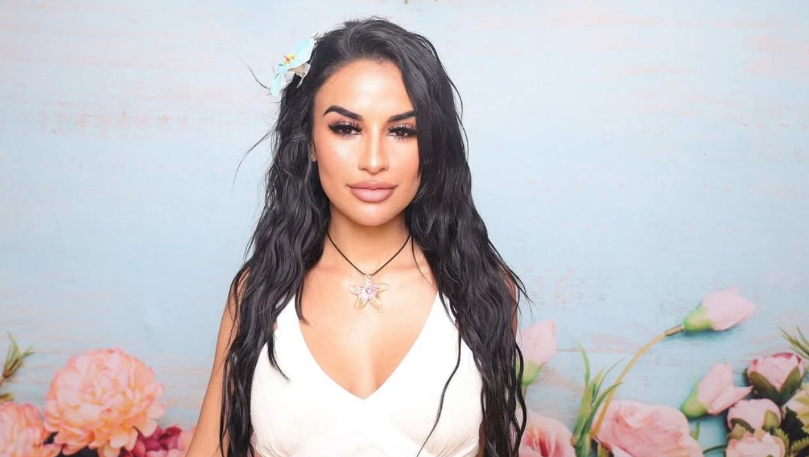 Yulissa Escobar smiling at the camera. She has a flower in her hair.