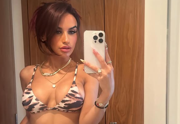 Yulissa Escobar is clicking a mirror selfie. Her hair is up in a messy bun.