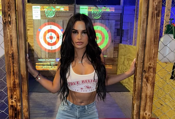 Yulissa Escobar is posing for the camera. She is standing in a doorway.