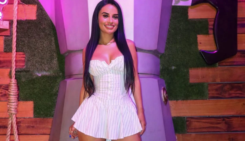 Yulissa Escobar is wearing a short white dress. She is smiling. 