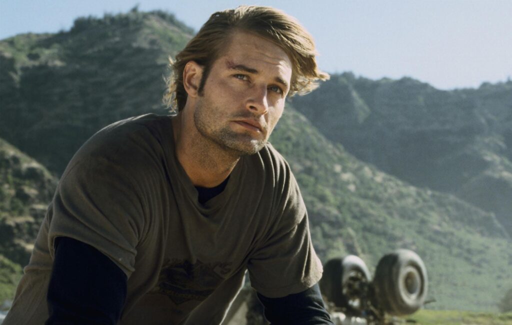Josh Holloway staring at a distance with the backdrop of scenic mountains