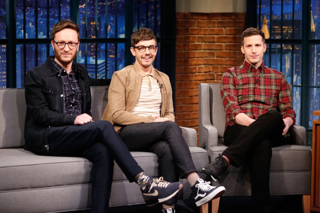 ‘Brooklyn 99’s Andy Samberg Made a Queer Anthem That Still Feels Illegally Underrated 8 A scene from an interview with Andy Samberg and his Lonely Island band members sitting on couches and smiling.