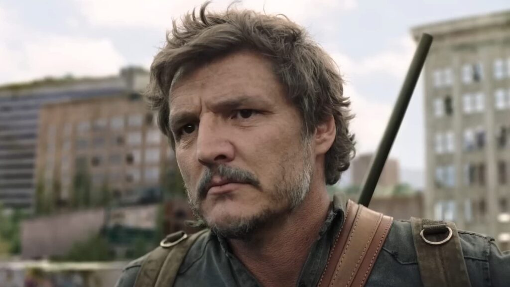 20 Absolutely Best TV Shows to Watch Right Now (June 2025) 59 A close-up of Joel with tousled hair looking intensely, positioned outdoors with blurred urban buildings visible in the background.