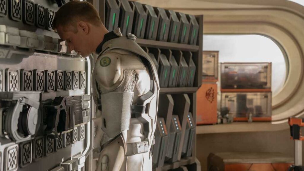 20 Absolutely Best TV Shows to Watch Right Now (June 2025) 61 Murderbot (Alexander Skarsgård) stands facing down in a futuristic corridor with control panels and equipment visible.