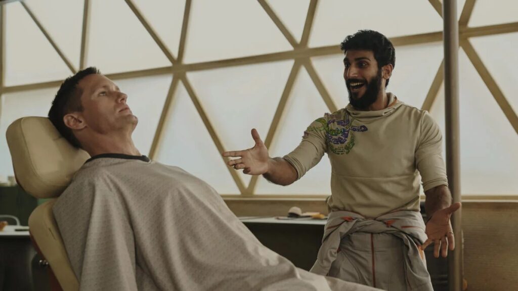 20 Absolutely Best TV Shows to Watch Right Now (June 2025) 65 Murderbot is laying down in a medical while Ratthi (Akshay Khanna) with a beard gestures as he speaks.