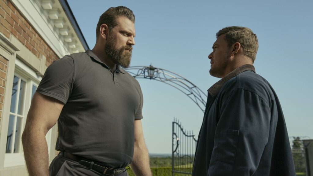 20 Absolutely Best TV Shows to Watch Right Now (June 2025) 92 Jack Reacher and Paulie facing off each other outdoors in a scene from the TV show "Reacher."