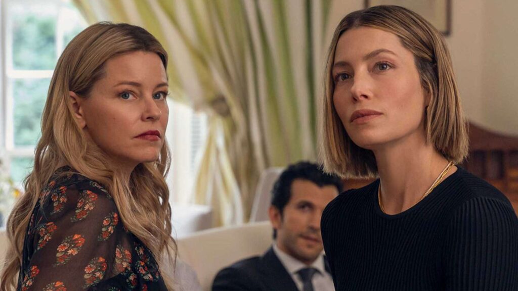 20 Absolutely Best TV Shows to Watch Right Now (June 2025) 96 Nicky Macintosh (Elizabeth Banks) and Chloe Taylor (Jessica Biel) in an elegant interior setting, with a man visible in the background.