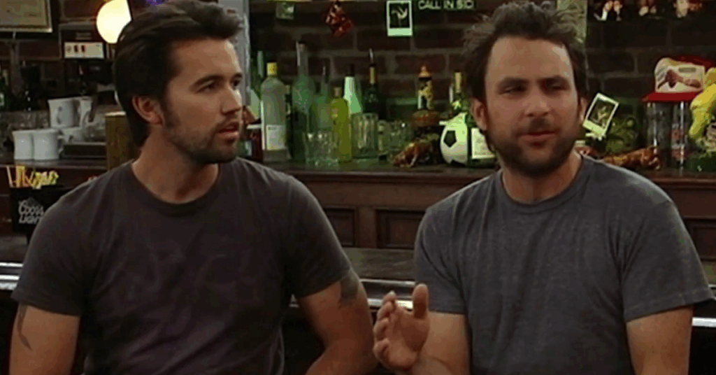 Rob Mcelhenney sitting at a bar counter. 
