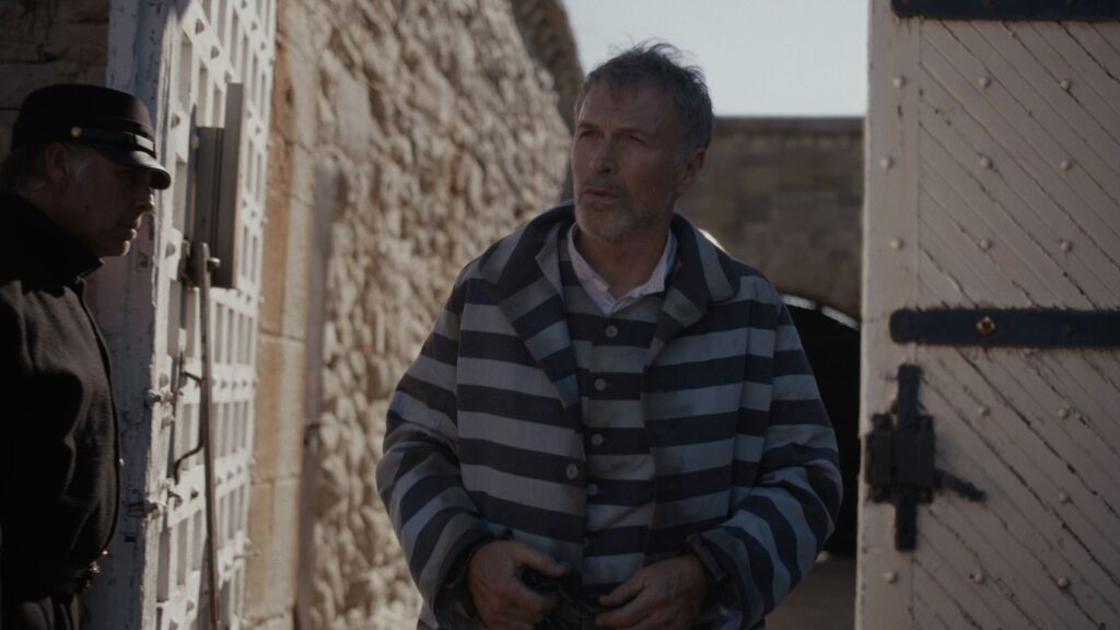 The Unholy Trinity Review — Blasphemy of a Once Proud Genre 5 A man in prison clothes
