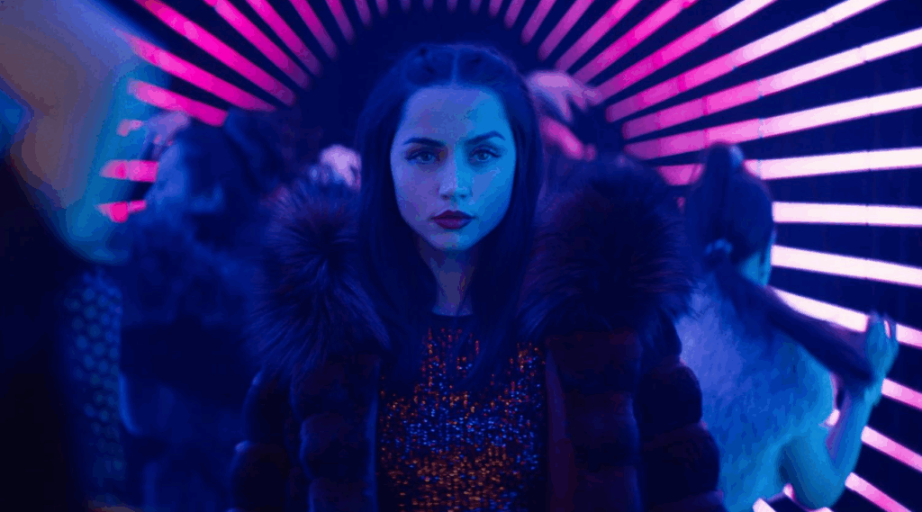 ‘Ballerina’ Box Office: Ana de Armas Scores the Third-Biggest Collection for Any ‘John Wick’ Movie in History 8 Eve Macarro is standing confidently in a neon-lit room, surrounded by partygoers.
