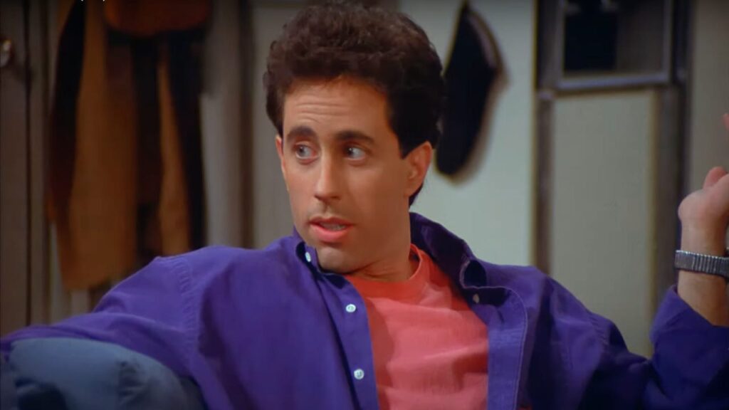 10 Insanely Popular TV Shows From the ‘90s You Can Stream on Netflix 5 Close-up of Jerry Seinfeld in his characteristic purple shirt.
